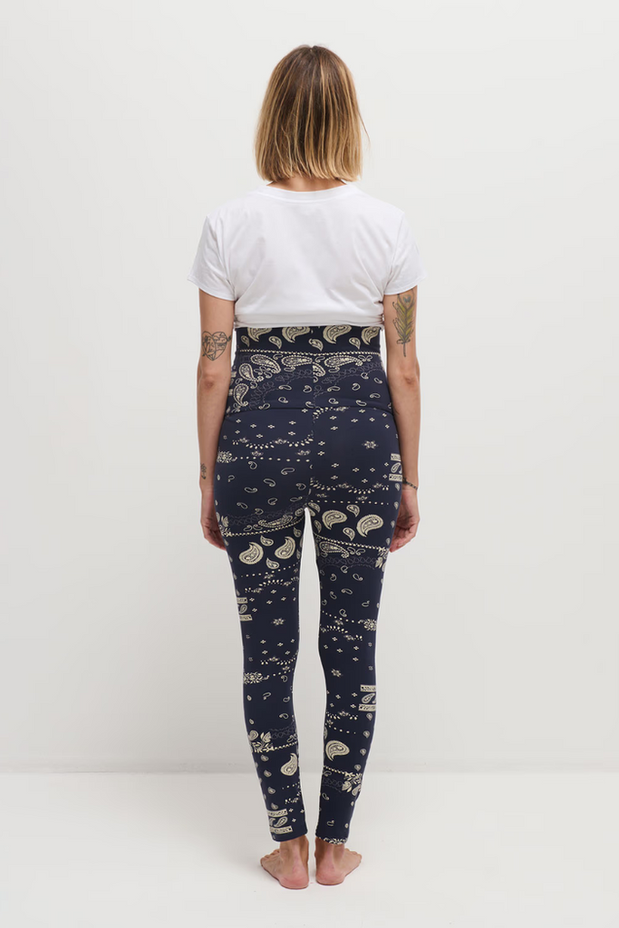 Femme enceinte portant un legging de grossesse bleu marine imprimé bandana, vue de dos.