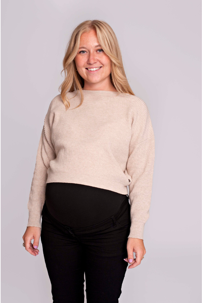 Femme enceinte portant un pull cropped beige lumineux, coupe confortable | MUMMY NANTES