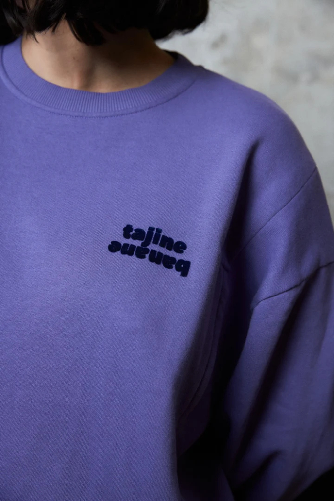 Zoom sur le logo Tajinebanane brodé en bleu indigo sur sweat d’allaitement violet | mummy nantes